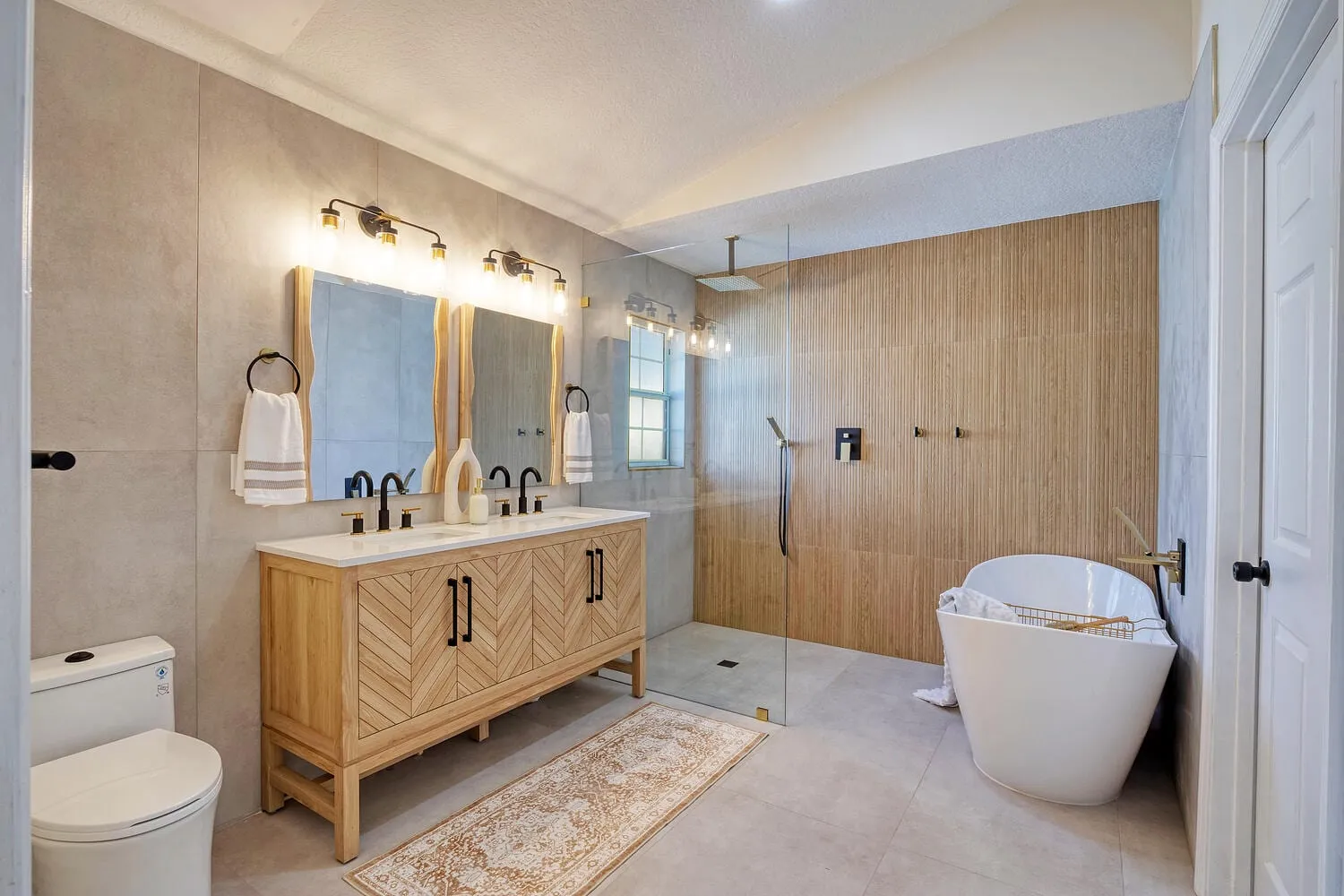 Primary bathroom rebuilt as a wet room with a curbless shower and a freestanding tub