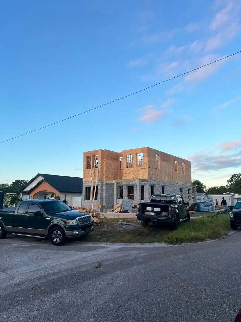 Second-floor wood framing standing on the block first floor at dusk
