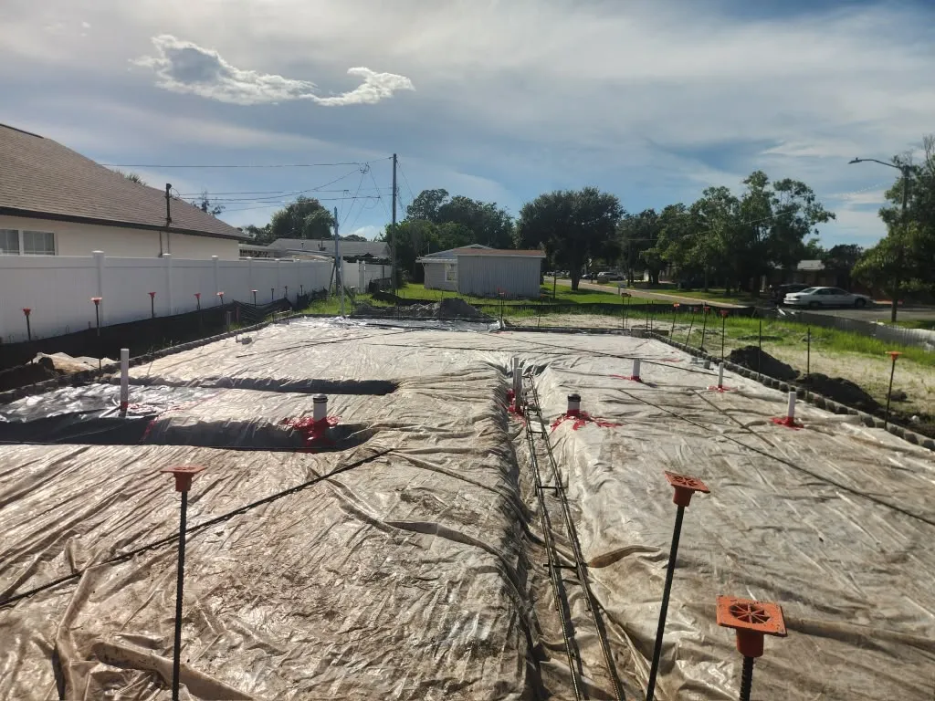 Slab prepared with vapor barrier, plumbing stubs and reinforcing steel